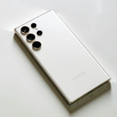 Close-up of the back of a white Samsung Galaxy smartphone, showing the vertical array of camera lenses and the Samsung logo on the back glass.